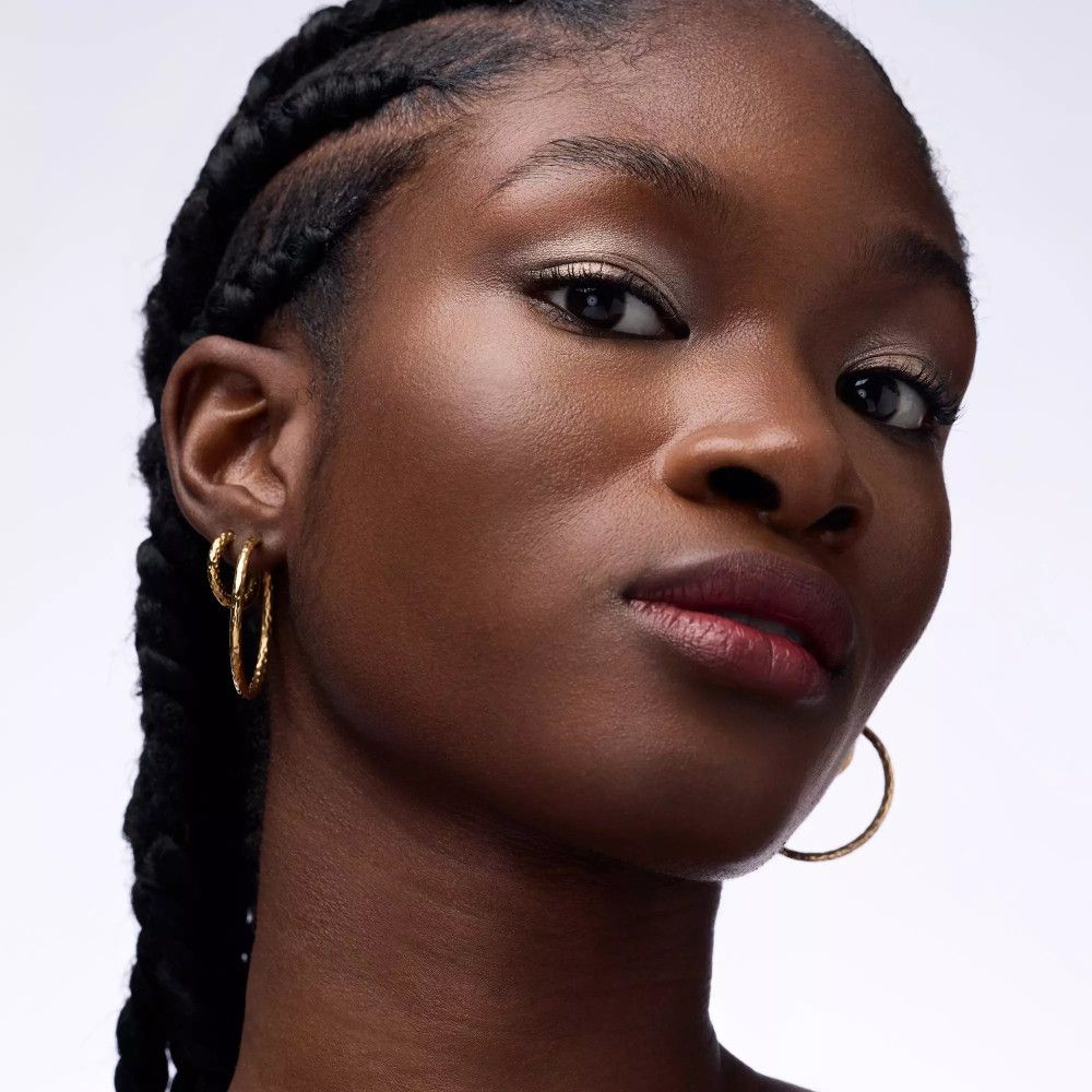 Porträt einer Frau mit geflochtenen Zöpfen. Augen-Make-up mit Lidschatten.