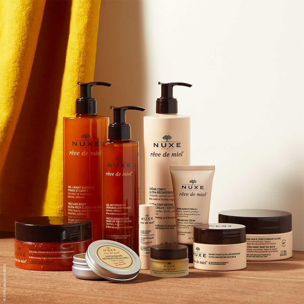 Verschiedene NUXE Rêve de Miel Produkte. Flaschen, Tiegel und Tuben. Beige und braune Verpackungen.