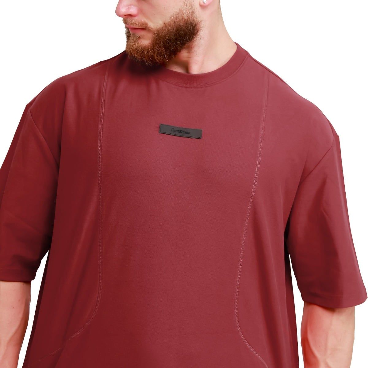 Rotes Oversize T-Shirt für Herren mit kurzen Ärmeln und einem schwarzen Logo-Patch auf der Brust.