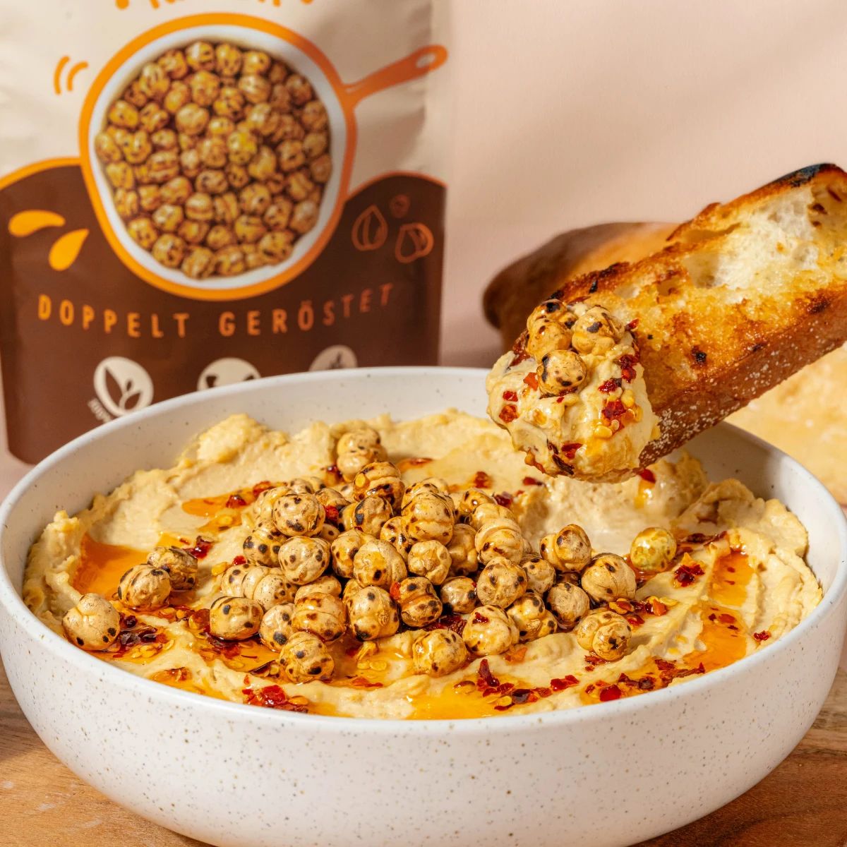 Hummus mit doppelt gerösteten Kichererbsen und Brot. Kichererbsen auf Hummus. Brot mit Hummus und Kichererbsen.