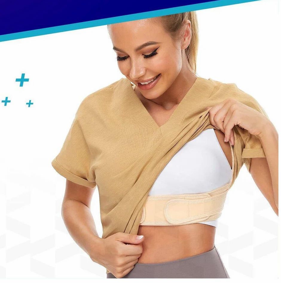 Frau mit Haltungskorrektor, beige. Trägt T-Shirt. Zeigt Produkt. Grauer Hintergrund.