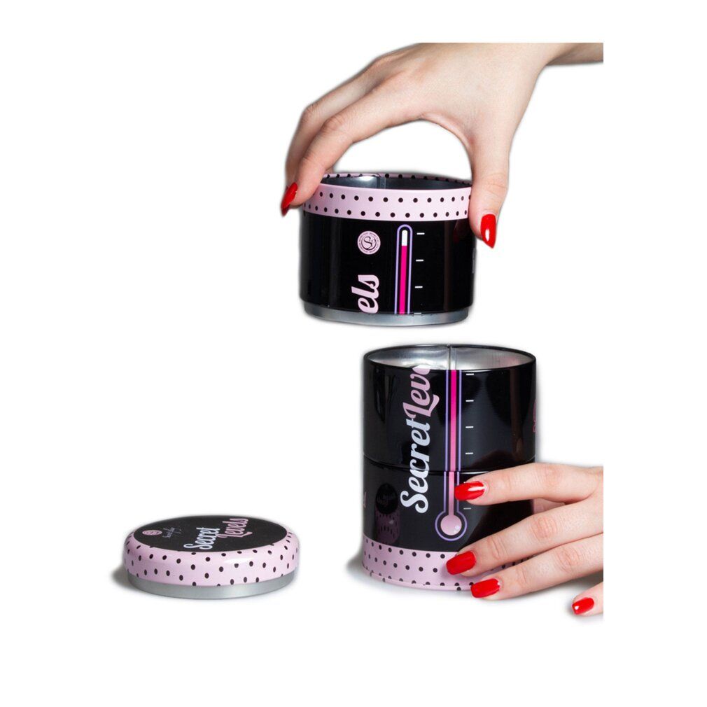 Schwarze Dose mit rosa Punkten und Schriftzug "Secret Levels". Rosa Thermometer-Design. Deckel abgenommen. Hände mit roten Nägeln.