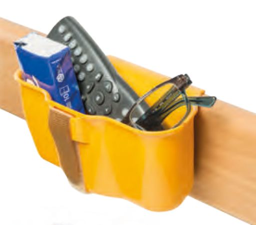 Gelbe Utensilientasche an Holz befestigt. Enthält Fernbedienung, Brille und Taschentücher.