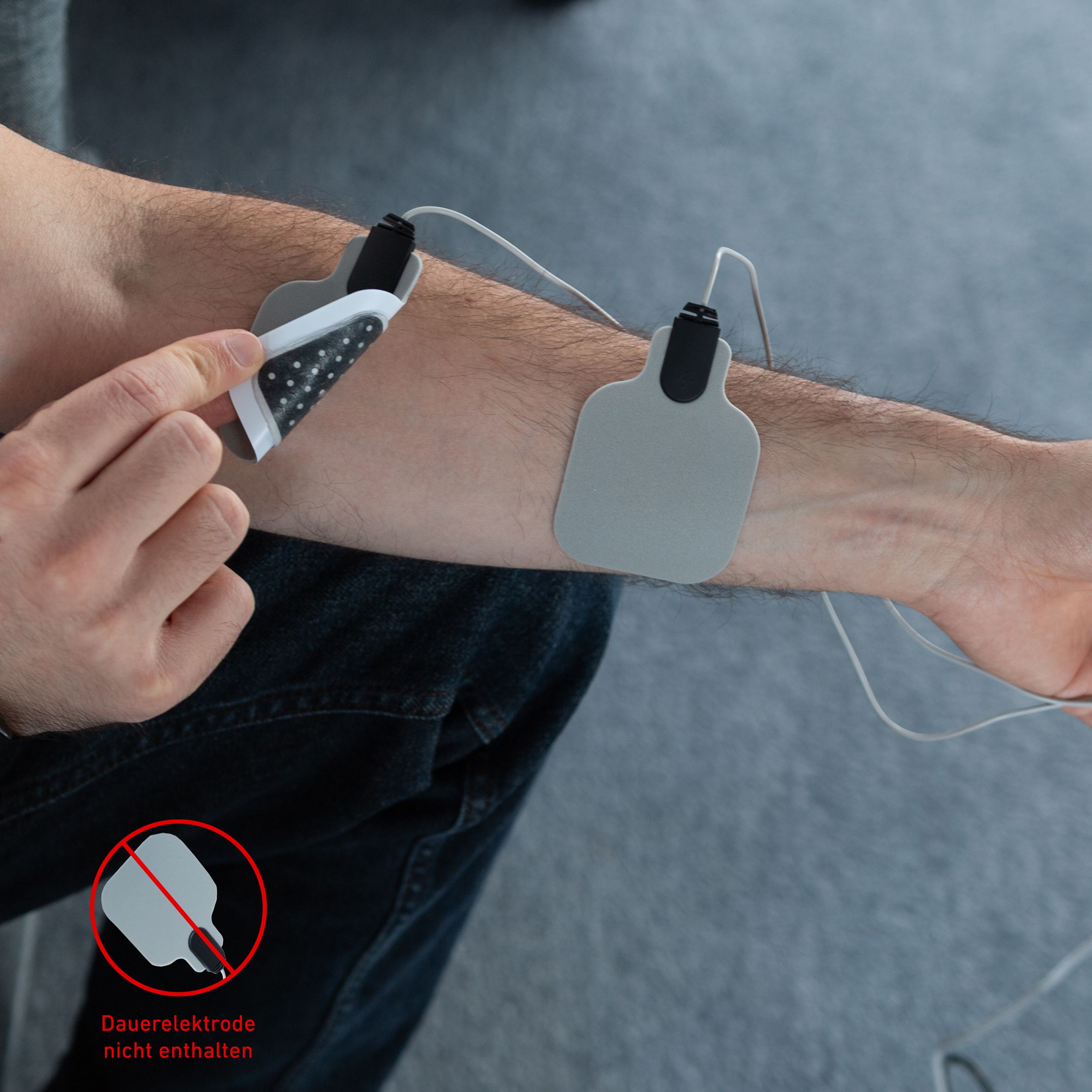 Person mit Elektroden am Arm. Graue Elektroden. Roter Kreis mit Symbol.