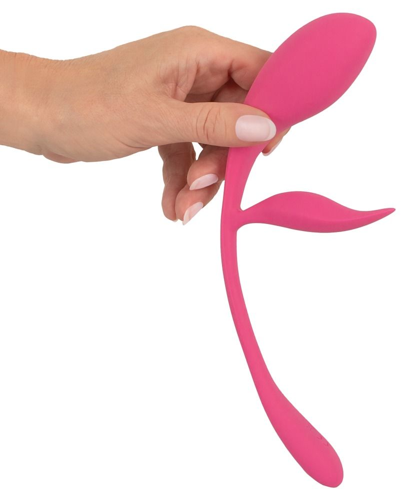 Rosa Wellness-Produkt, gehalten von einer Hand. Zwei gebogene Arme und ein zentrales Element. Glatte Oberfläche, abgerundete Formen.