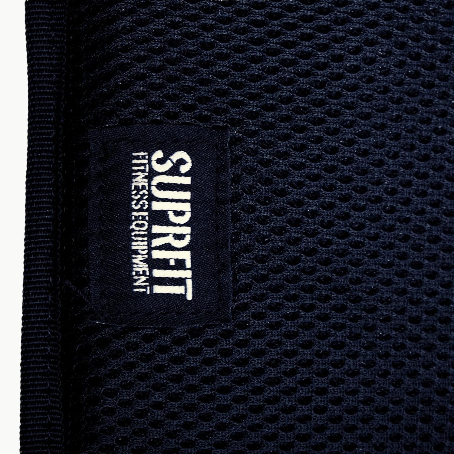 Nahaufnahme des SUPRFIT-Logos auf einem blauen Mesh-Gewebe. Text: FITNESS EQUIPMENT.