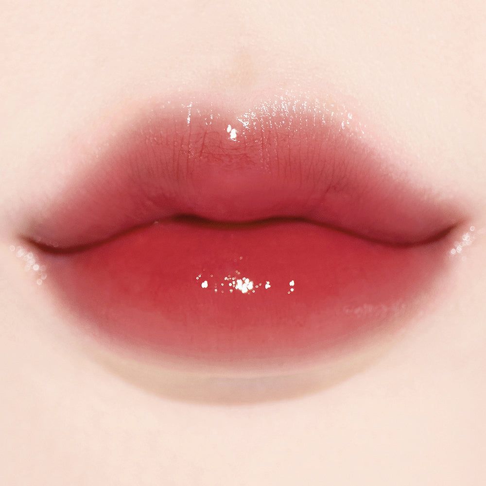 Glänzende Lippen mit rotem Farbverlauf und Glitzerpartikeln.