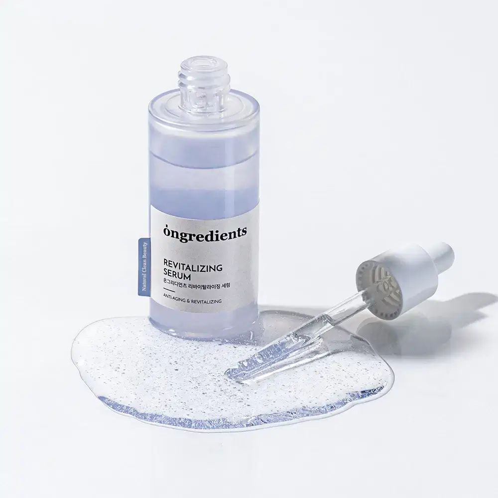 ONGREDIENTS Revitalizing Serum. Flasche und Pipette mit Serum auf weißem Untergrund. Produktname und Text.