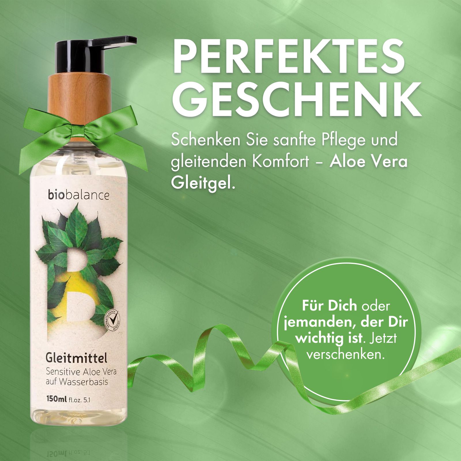 Gleitmittel-Flasche mit Holzdeckel und Pumpkopf, mit grünem Band verziert. Text: Perfektes Geschenk.