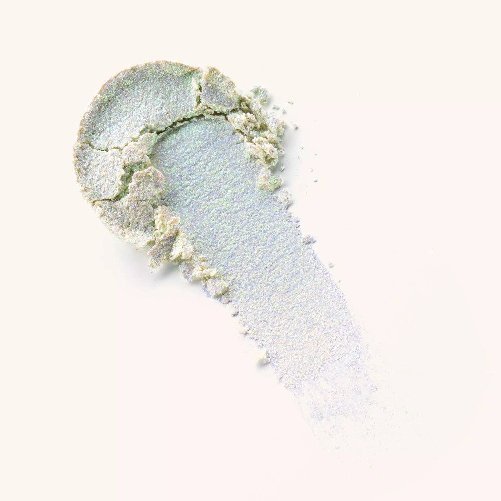 Abstrich von silberfarbenem Lidschatten. Der Lidschatten ist leicht zerbröckelt und hat eine glänzende Oberfläche.