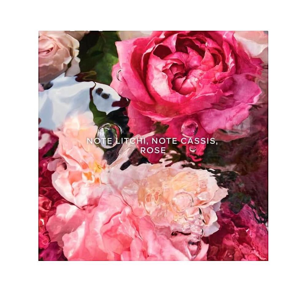 Nahaufnahme von Rosenblüten in verschiedenen Rosatönen. Text: "NOTE LITCHI, NOTE CASSIS, ROSE".