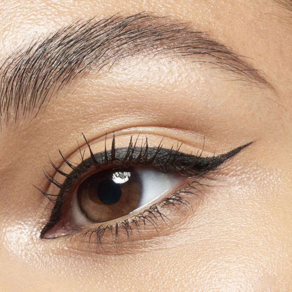 Nahaufnahme eines Auges mit schwarzem Eyeliner. Der Eyeliner ist am äußeren Augenwinkel geflügelt.