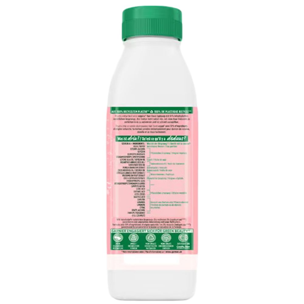 Flasche Garnier Fructis Volumen Spülung. Weiß, rosa Etikett mit Text. Grüner Deckel. Nachhaltigkeitszertifizierungen.