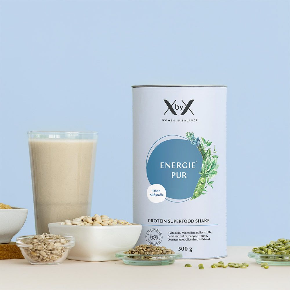 Zylinderdose mit Produktaufdruck. Glas mit Shake. Schalen mit Samen und Körnern. Aufschrift: Energie Pur, Protein Superfood Shake.