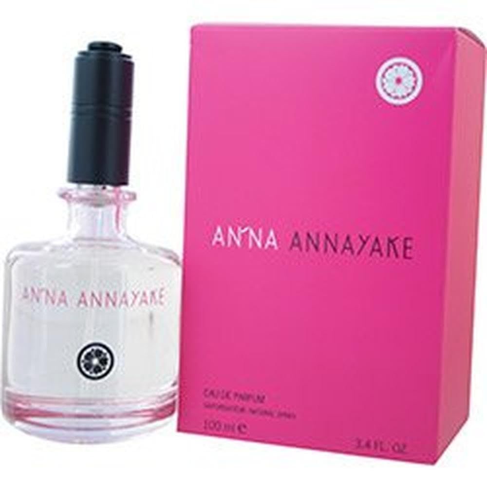 Parfümflasche und Verpackung. Flasche mit schwarzem Verschluss, rosa Flüssigkeit. Rosa Verpackung mit weißem Logo und Schriftzug.