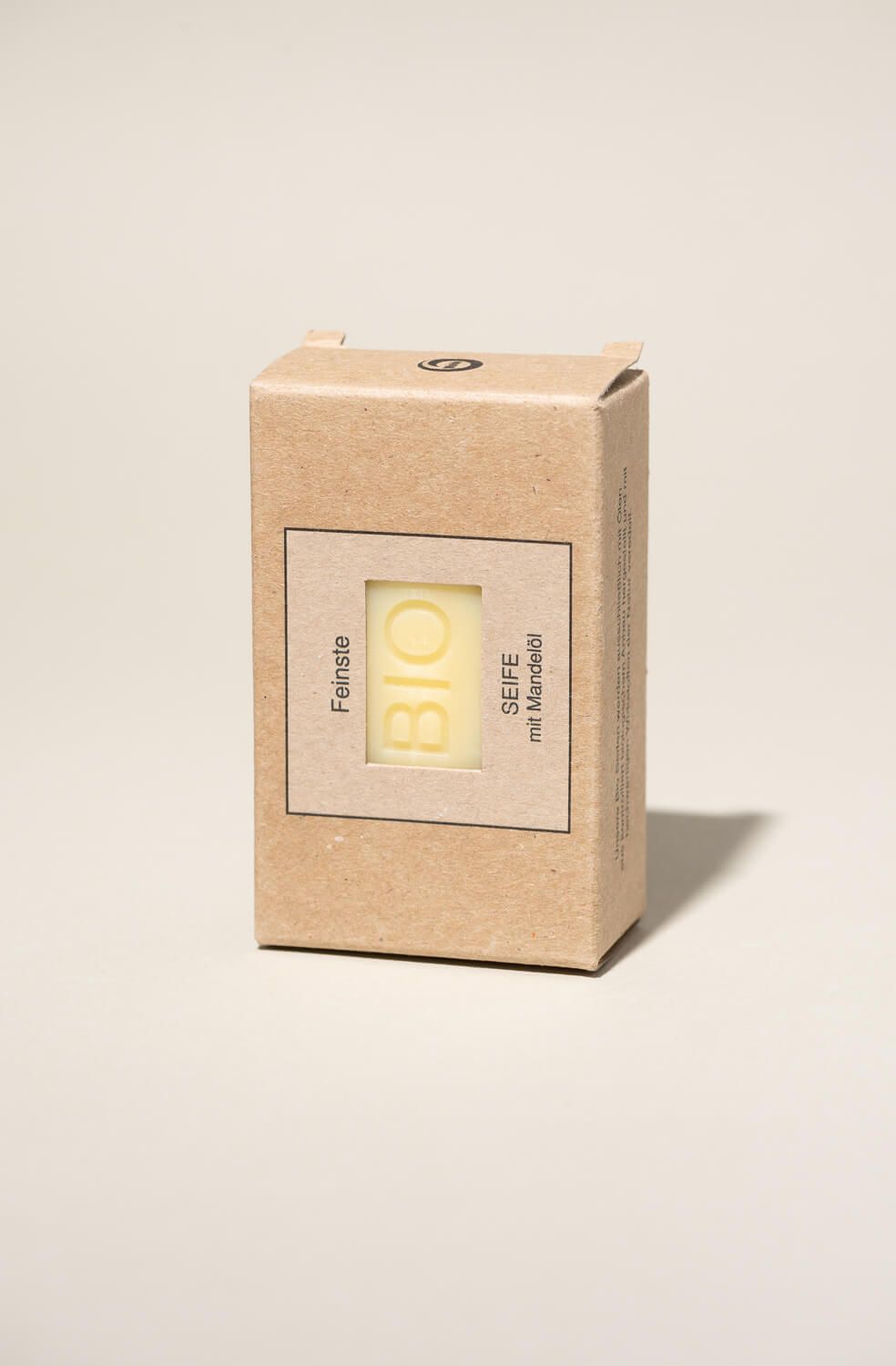 Seife in Kartonverpackung. Aufschrift "BIO SEIFE mit Mandelöl". Fenster zeigt Seife. Braune Verpackung.