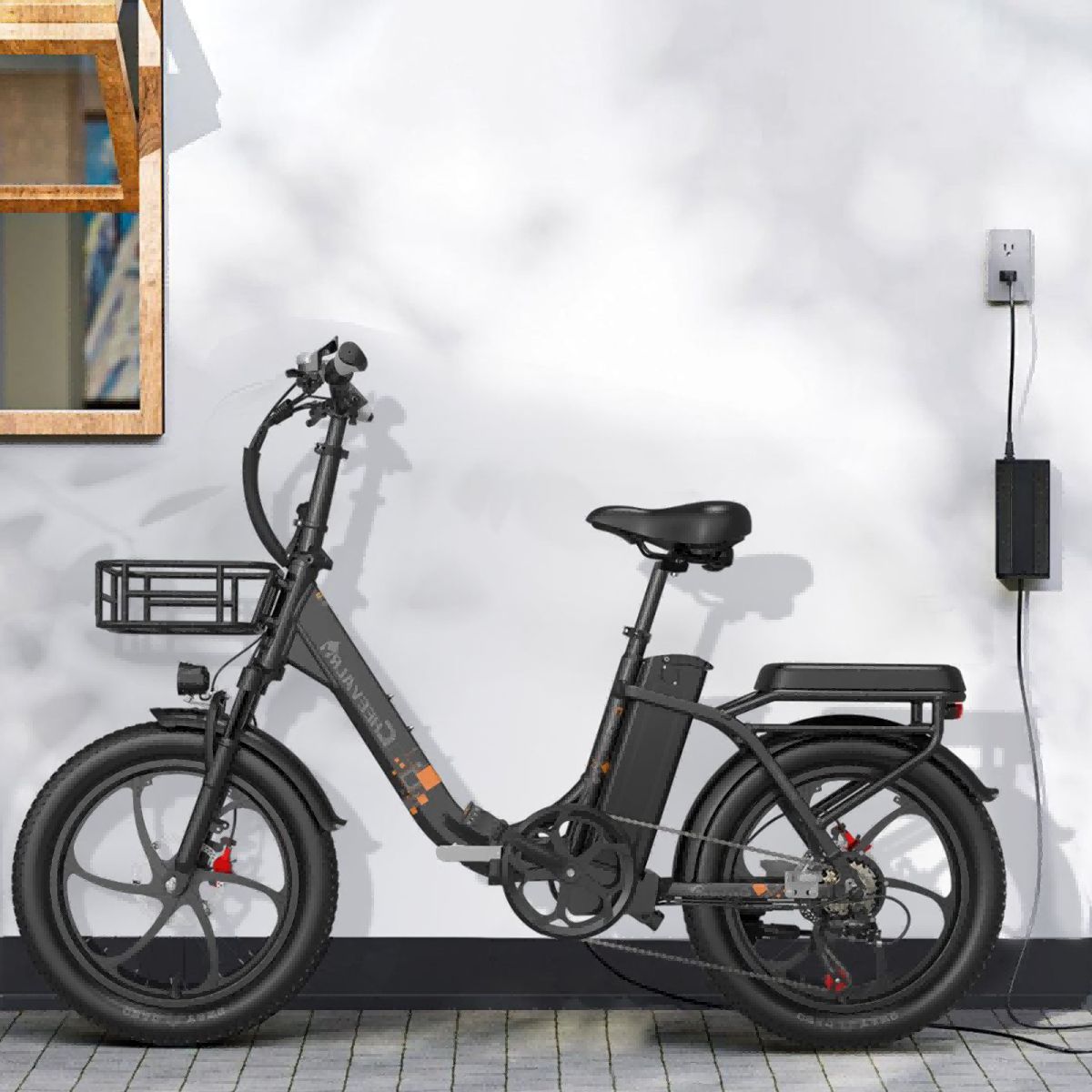 Schwarzes Elektrofahrrad mit Korb, an Wand mit Steckdose und Ladegerät. Sattel und Lenker sind sichtbar.