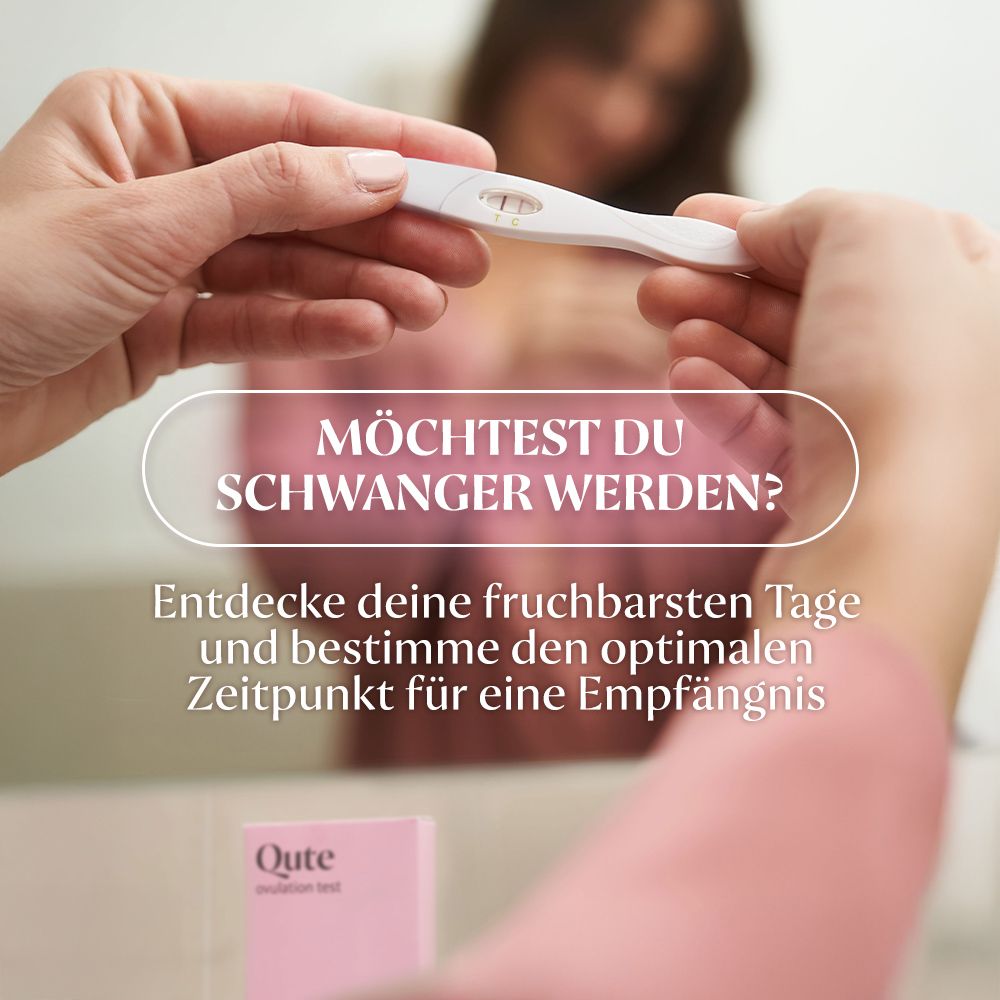 Eine Frau hält einen Ovulationstest. Aufschrift: Qute Ovulationstest. Rosa Verpackung im Hintergrund.