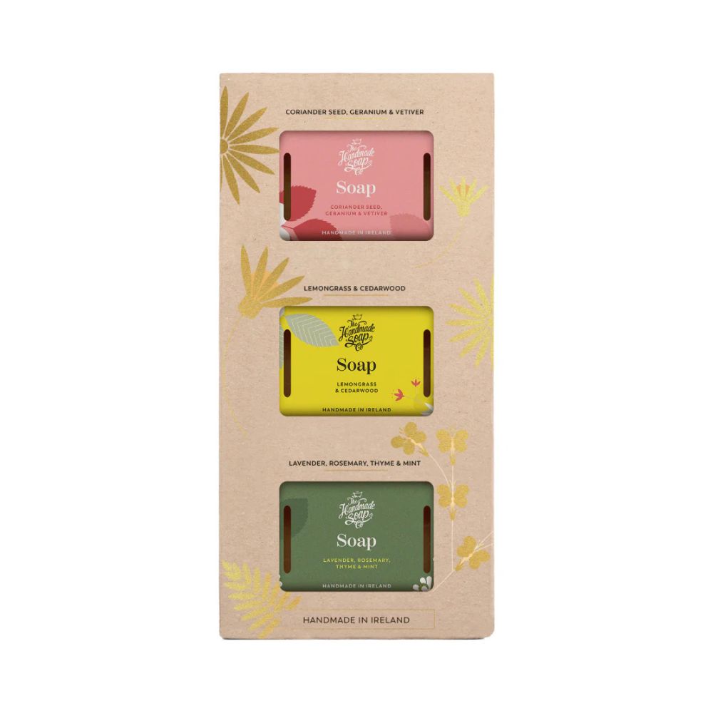 Geschenkset mit drei Seifenstücken in verschiedenen Farben. Verpackung aus Karton mit floralen Elementen. Beschriftung: Handmade Soap.