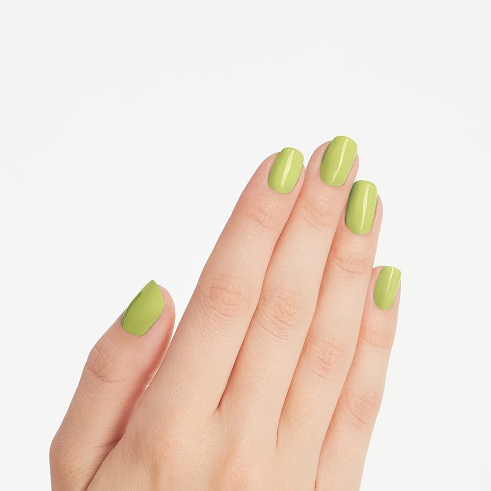 Hand mit fünf lackierten Fingernägeln. Die Nägel sind oval und mit grünem Nagellack lackiert. Heller Hintergrund.