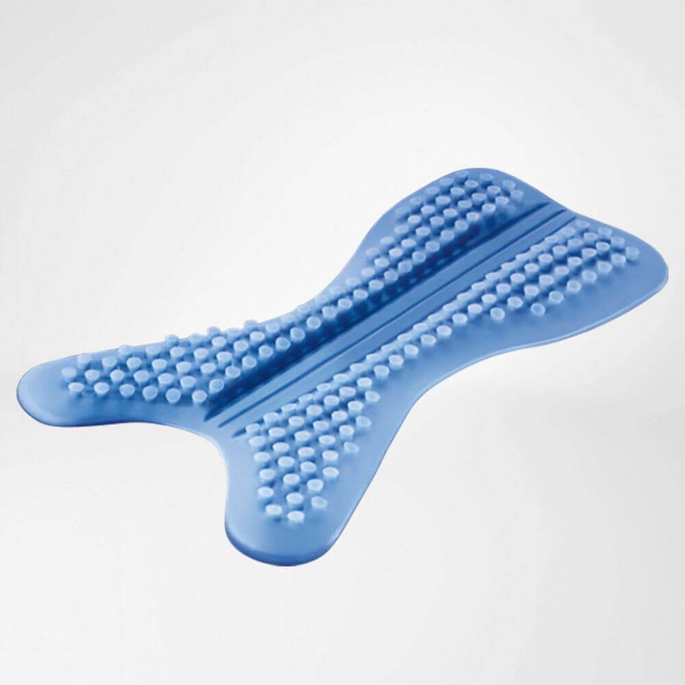 Mann kniet auf Rasen, trägt eine Knöchelbandage. Er interagiert mit einem Hund. Im Hintergrund ein Haus.