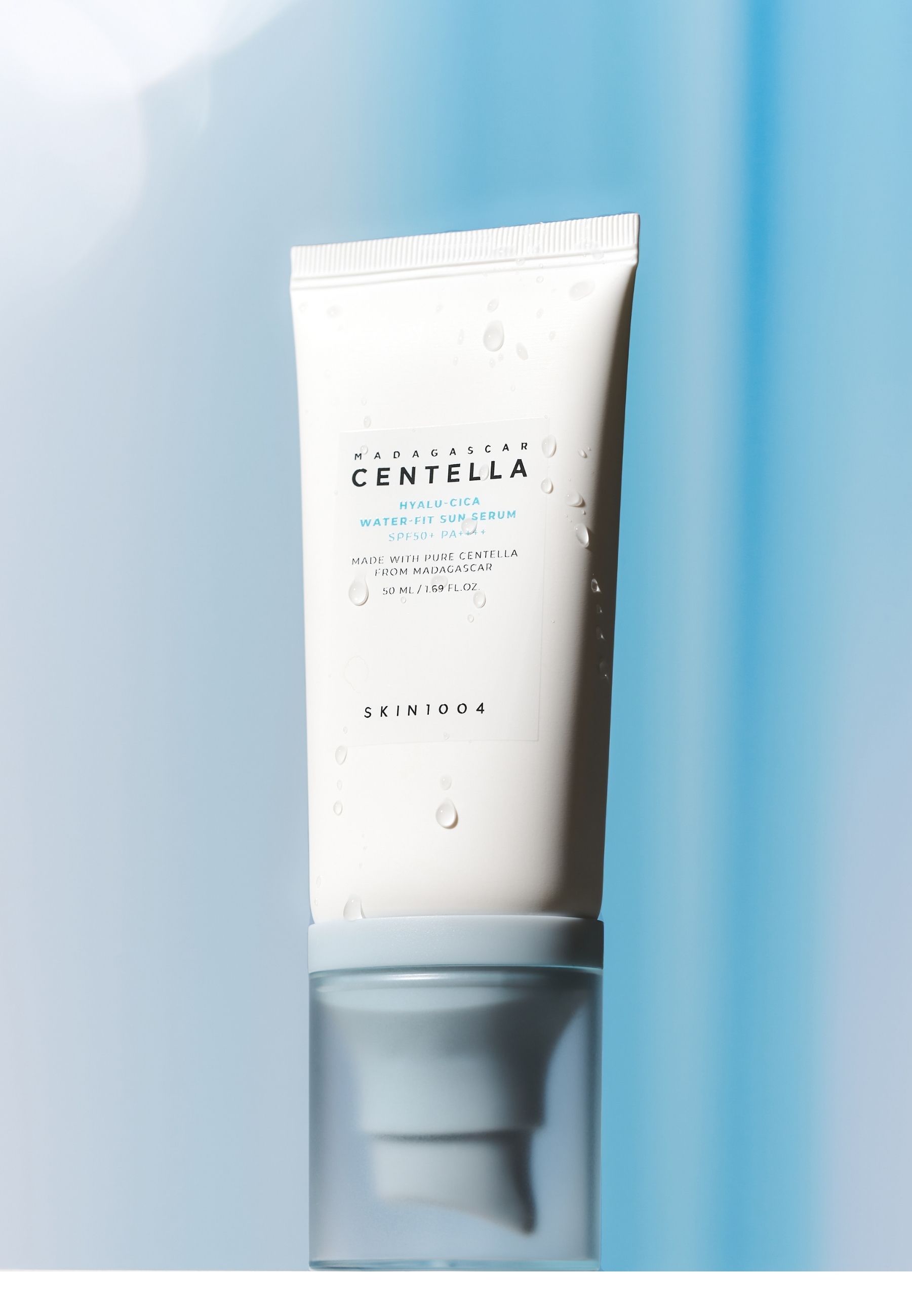 Weiße Tube mit blauem Deckel. Aufschrift: MADAGASCAR CENTELLA HYALU-CICA WATER-FIT SUN SERUM. Marke SKIN1004.
