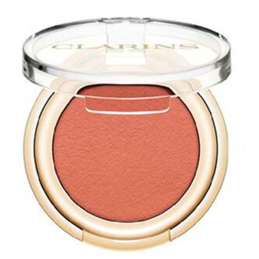 Runder Lidschattenbehälter mit rosabraunem Lidschatten. Deckel geöffnet. Goldfarbener Rand. Klarer Deckel mit Markenschriftzug.