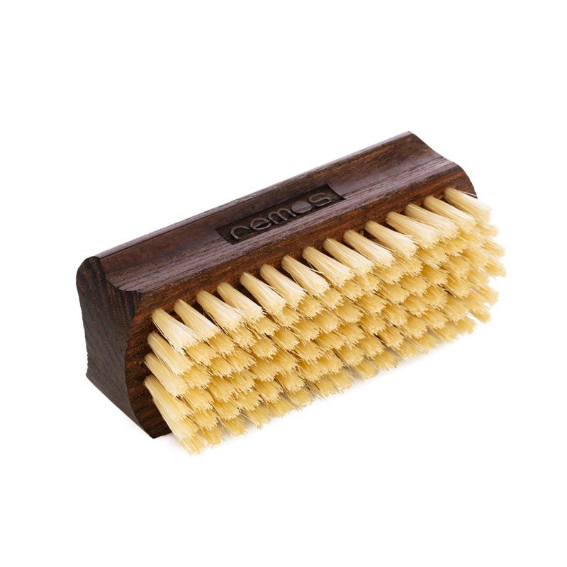 Hand- und Nagelbürste aus Holz mit hellen Borsten. Dunkles Holzgehäuse, rechteckige Form, Borsten auf zwei Seiten. REMOS-Logo.