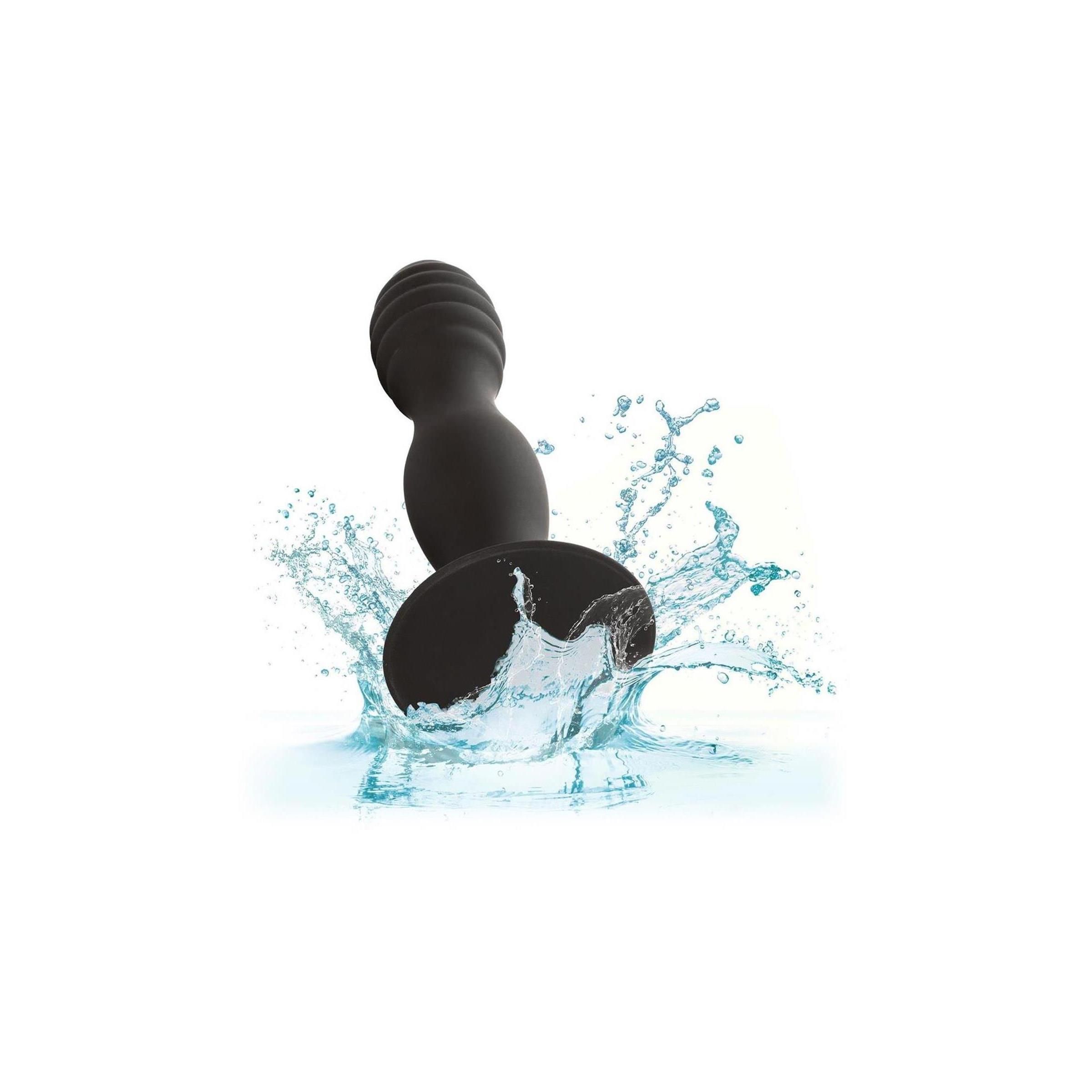 Schwarzer Anal-Stift im Wasser. Gerippte Spitze, Saugnapf-Basis. Spritzwasser.