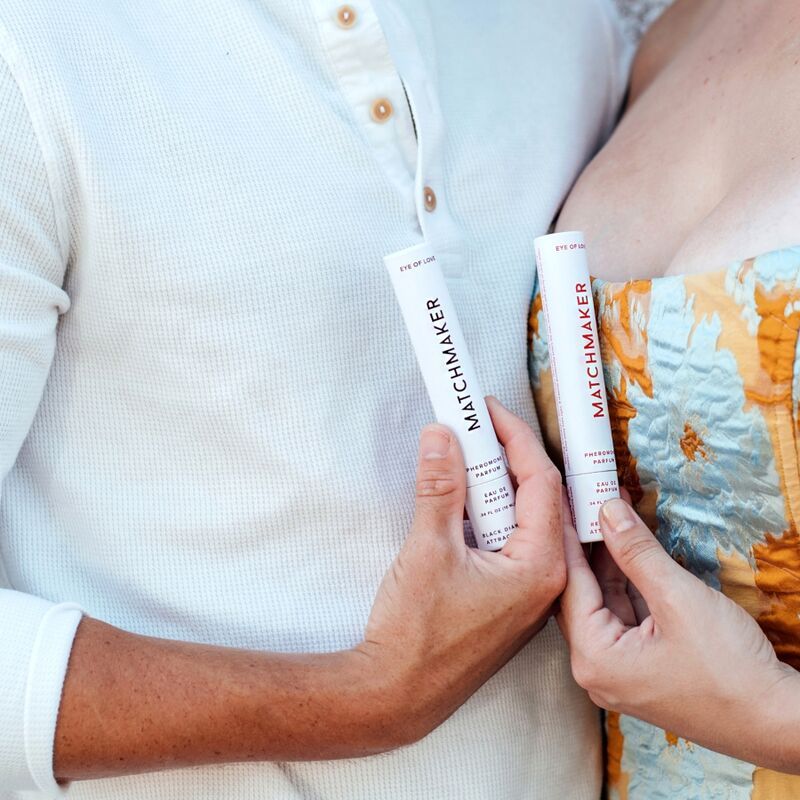 Zwei Flakons mit roter Flüssigkeit. Aufschrift MATCHMAKER. Hände halten Flakons. Hintergrund: hell.