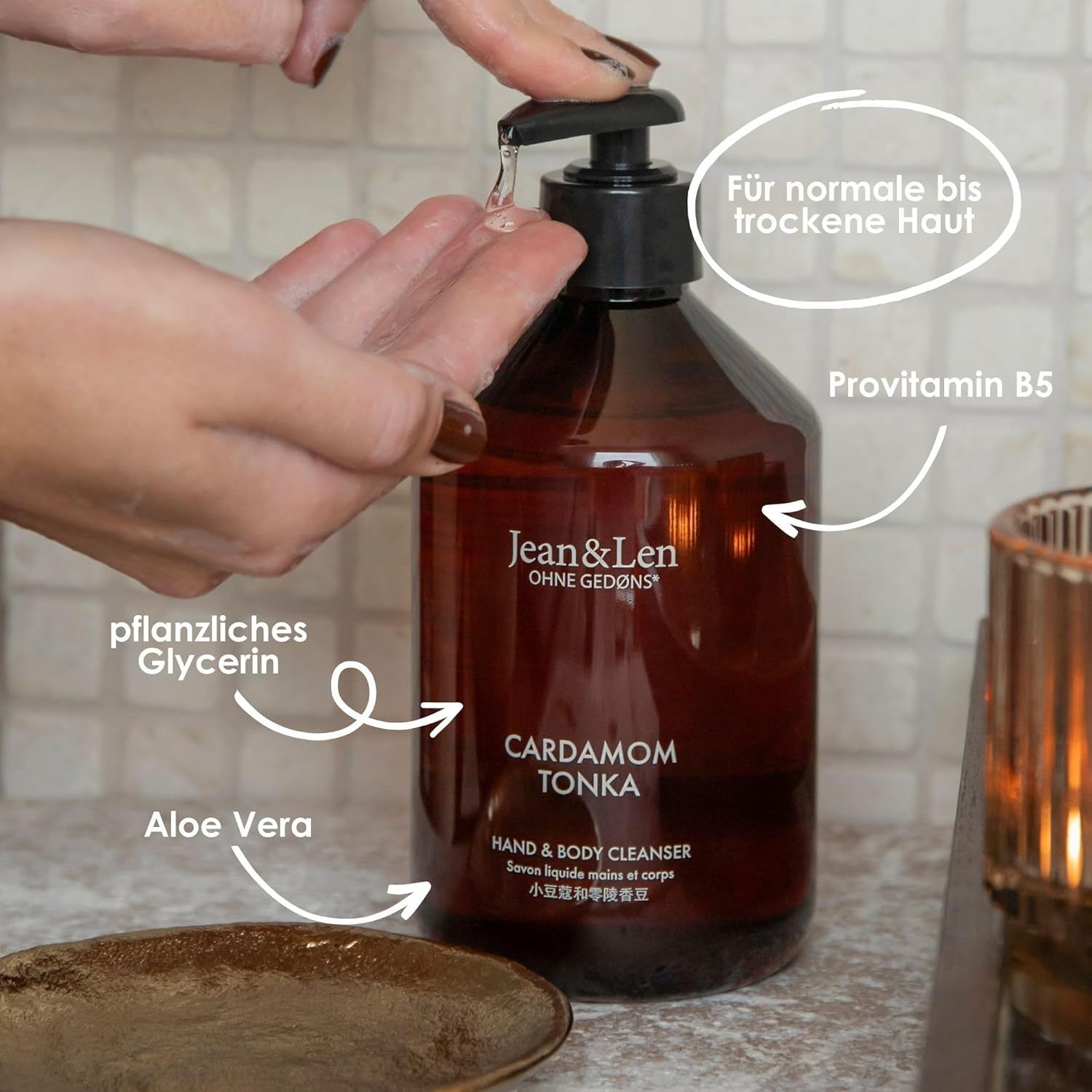 Braune Flasche mit schwarzem Pumpaufsatz. Aufschrift: Cardamom Tonka. Hand & Body Cleanser. Pflanzliches Glycerin, Aloe Vera.