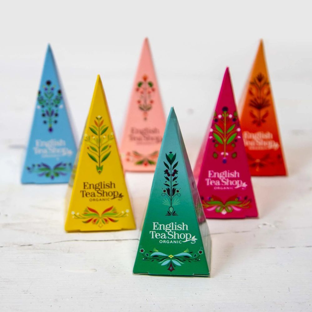 Sechs farbige Pyramiden-Teebeutel. Aufschrift: English Tea Shop Organic. Verschiedene Farben: blau, gelb, rosa, grün, pink, orange.