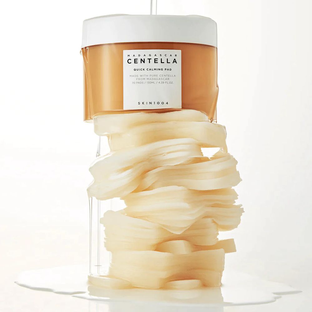 Produktbehälter mit Pads und Flüssigkeit. Text: CENTELLA QUICK CALMING PAD. Marke: SKIN1004. Pads sind sichtbar.