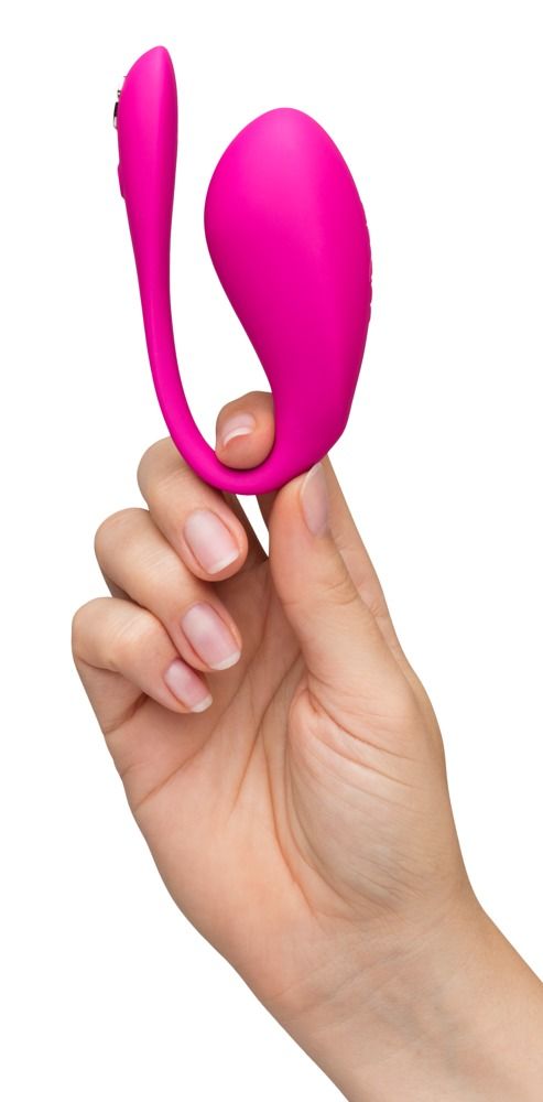 Pinkfarbener Vibrator in einer Hand gehalten. Geschwungene Form.