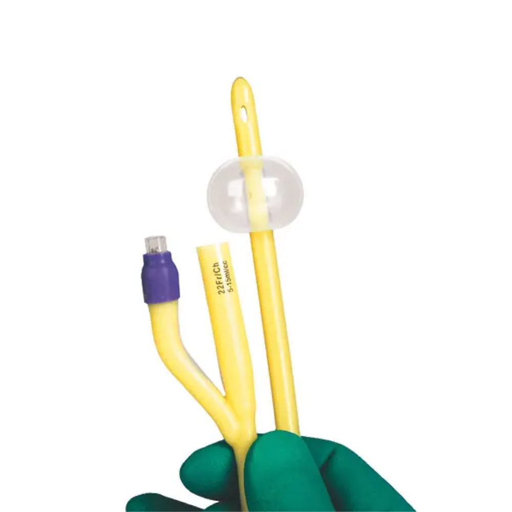 Gelber Ballonkatheter mit transparentem Ballon, gehalten von einer Hand mit grünem Handschuh.