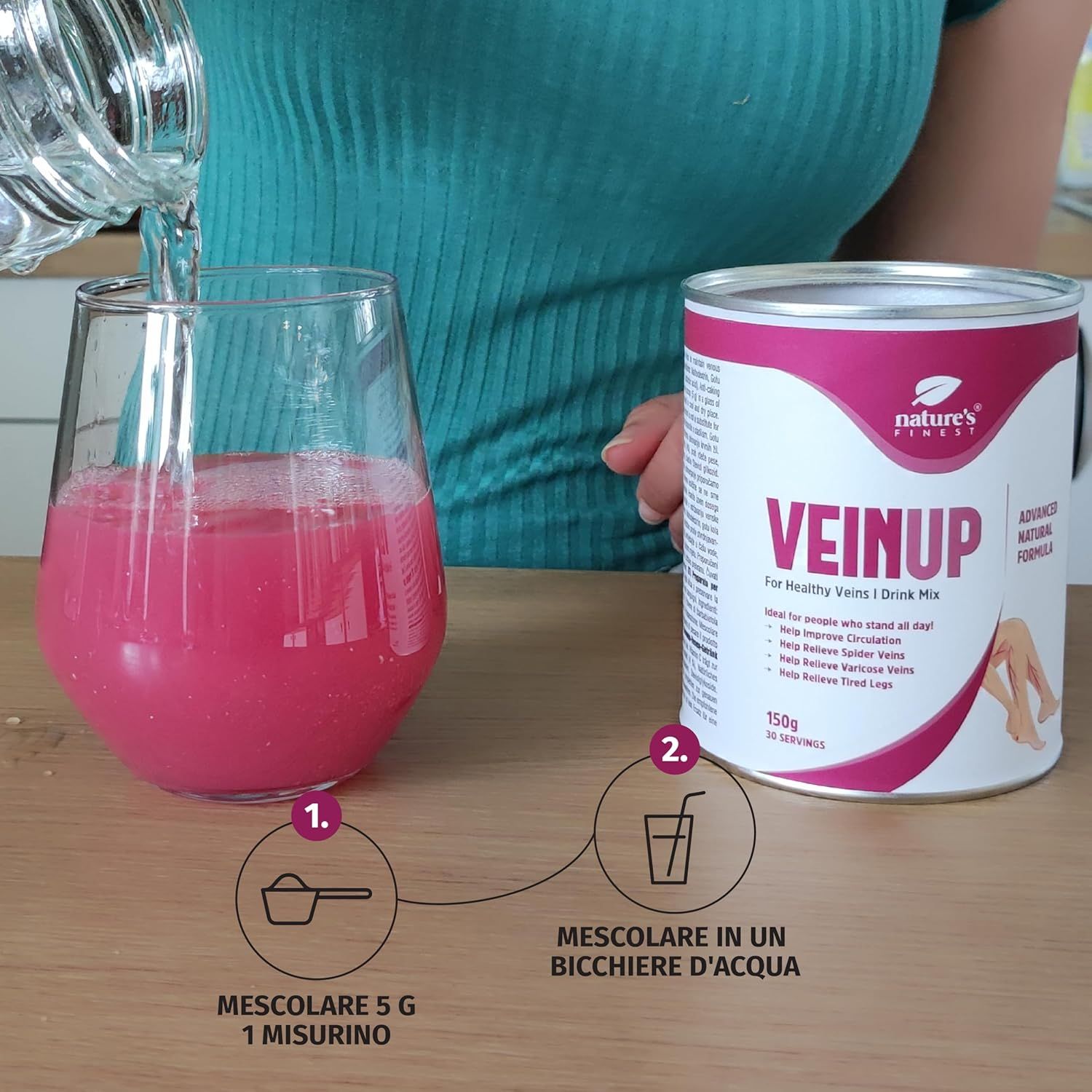 Person gießt Wasser in Glas mit rosa Flüssigkeit. Dose Nature's Finest VEIN UP daneben. Anweisungen.