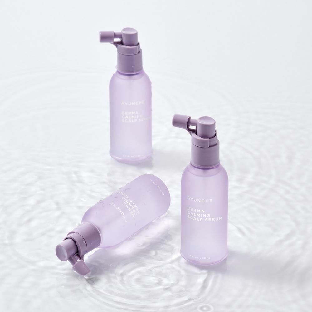 Drei Flaschen AYUNCHE Derma Calming Scalp Serum auf Wasser.