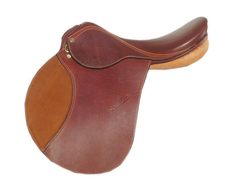 Brauner Sattel mit hellbraunen und dunkelbraunen Lederteilen. Goldfarbene Metallbeschläge. Nahaufnahme, weißer Hintergrund.