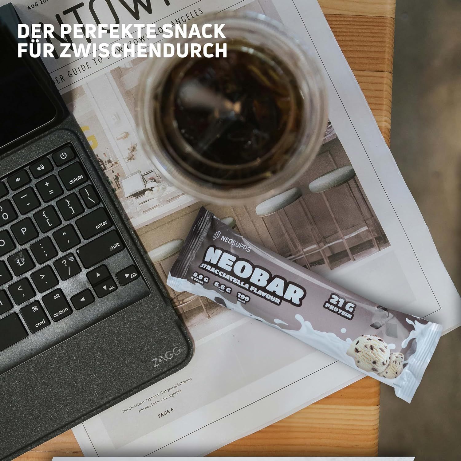 NEOBAR Proteinriegel auf Papier und neben einem Laptop und einem Getränk. Aufdruck: NEOBAR, 21g Protein, Stracciatella Flavour.