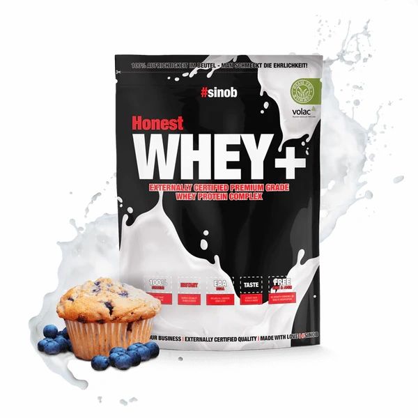 Schwarze Verpackung mit weißem Schriftzug "Honest WHEY+". Blaubeermuffin und Blaubeeren daneben. Milchspritzer im Hintergrund.