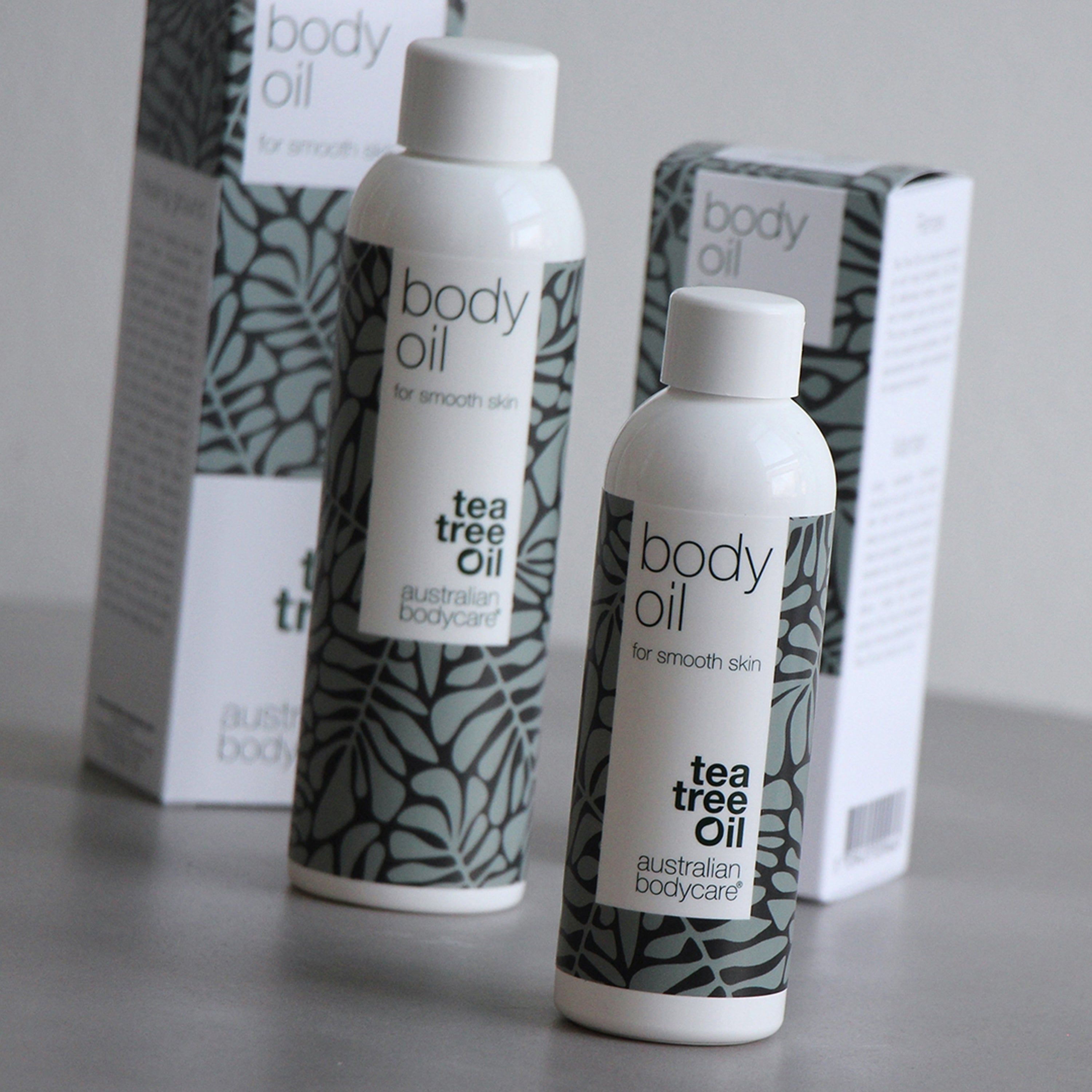 Zwei Flaschen und zwei Schachteln. Aufschrift: body oil, for smooth skin, tea tree oil, australian bodycare.
