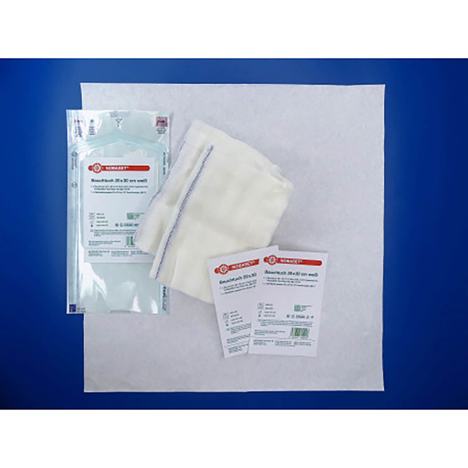 Ausgepackte Bauchtücher und Verpackung. NOBASET, 20x30 cm, weiß. Zwei Packungen, ein Tuch, zwei Etiketten.