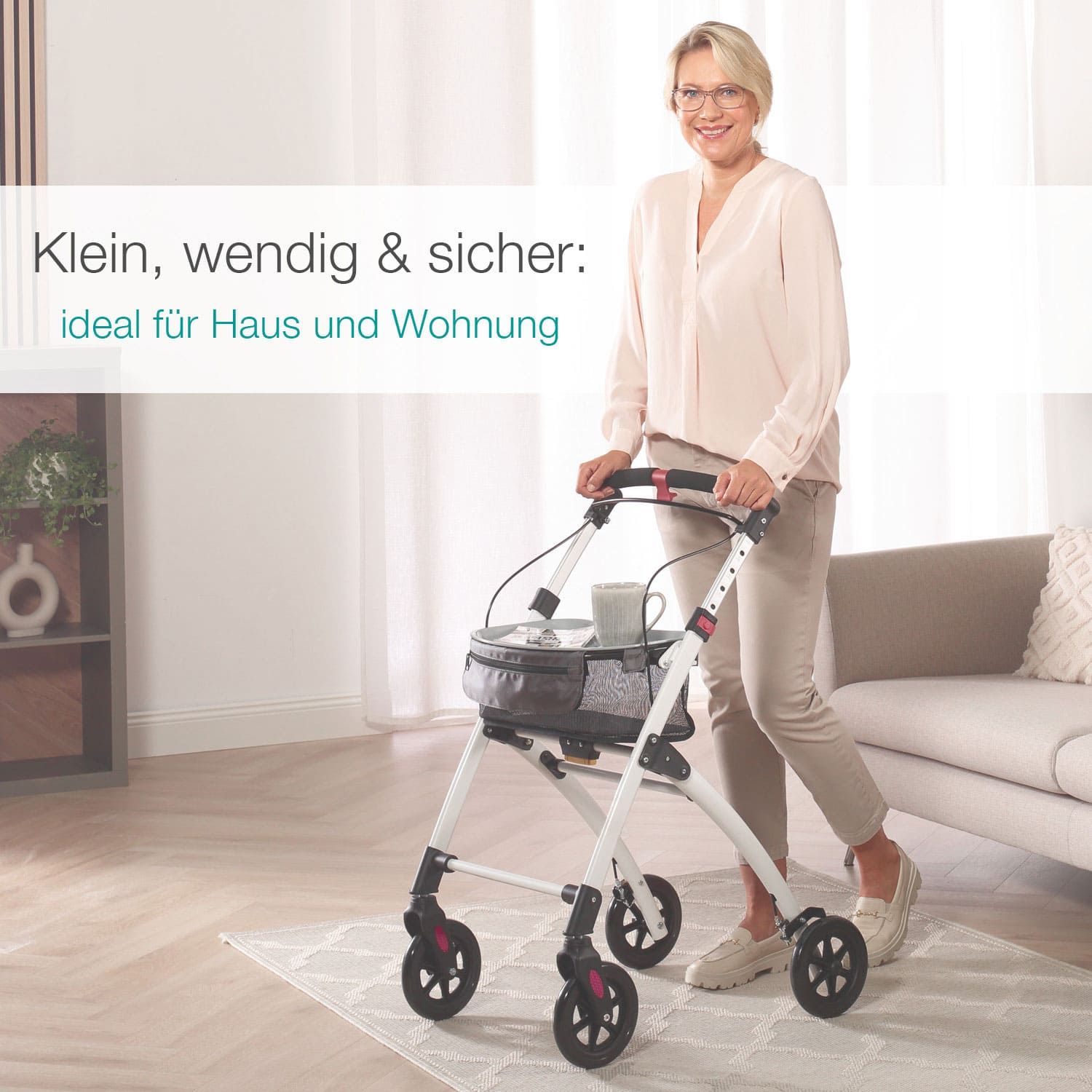 Frau mit Rollator in Wohnzimmer. Weißer Rahmen, schwarze Räder und Korb. Text: Klein, wendig & sicher: ideal für Haus und Wohnung.