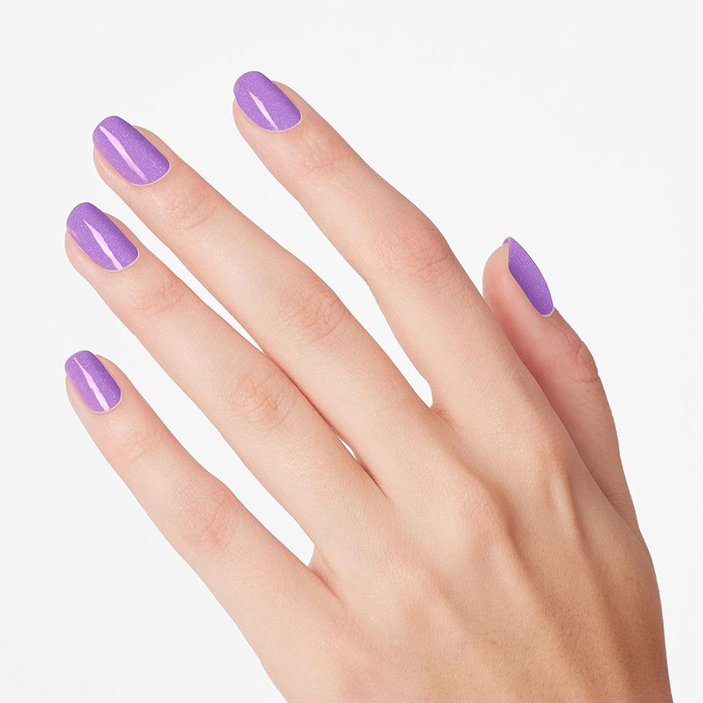 Hand mit lackierten Nägeln in Lila. Fünf lackierte Fingernägel.