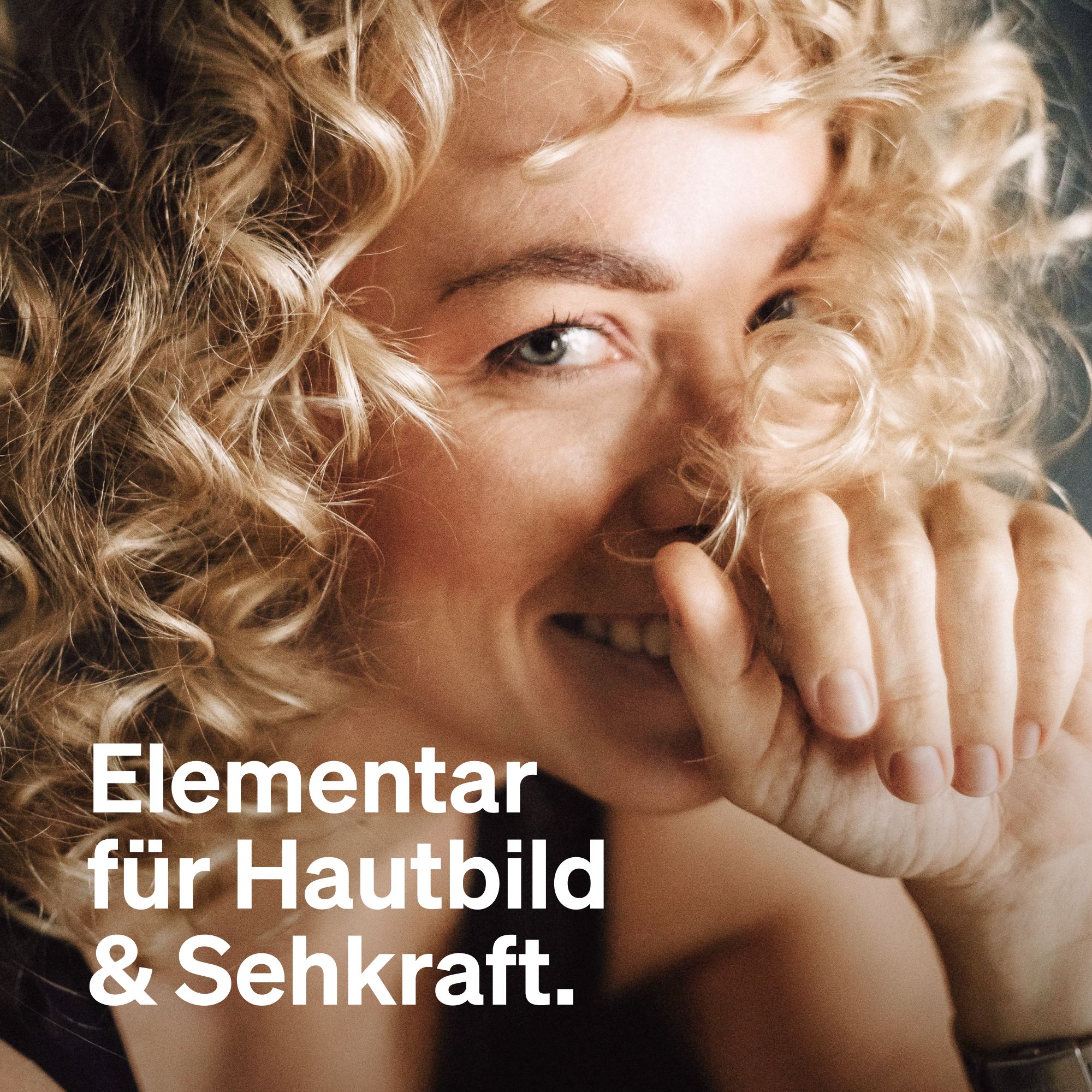 Porträt einer Frau mit blonden Locken, lächelnd. Text: "Elementar für Hautbild & Sehkraft."