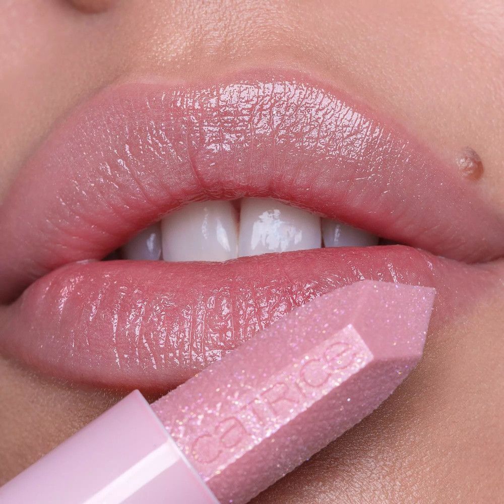 Nahaufnahme von Lippen, die mit rosa Lippenbalsam bestrichen sind. Der Lippenbalsam wird aufgetragen. Marke: Catrice.