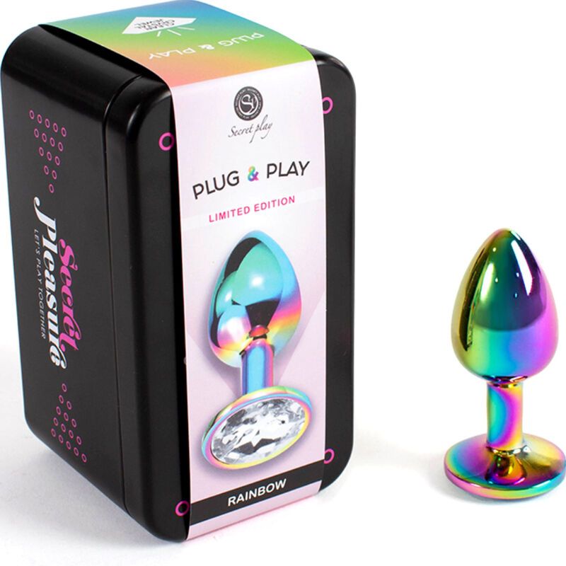 Regenbogenfarbener Metall-Butt Plug mit Kristall-Basis, neben schwarzer Dose mit Aufschrift "Secret Pleasuria".