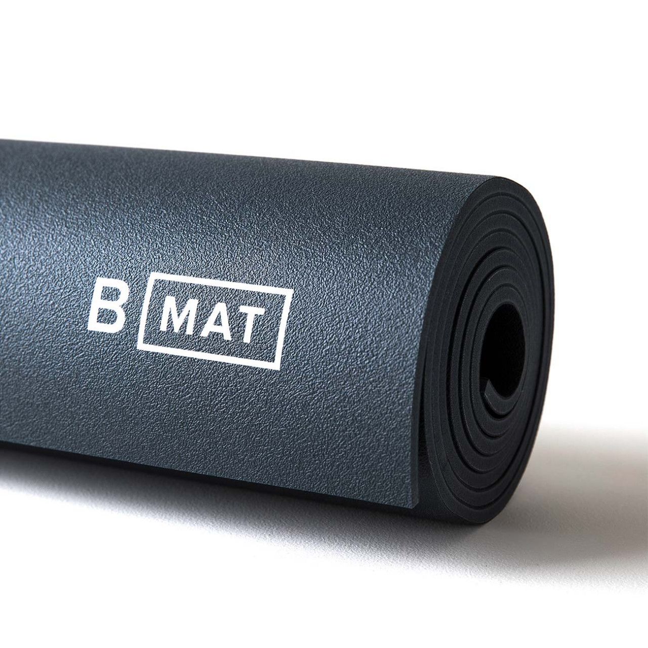 Gerollte Yogamatte, graue Farbe, mit Logo "B MAT". Nahaufnahme.