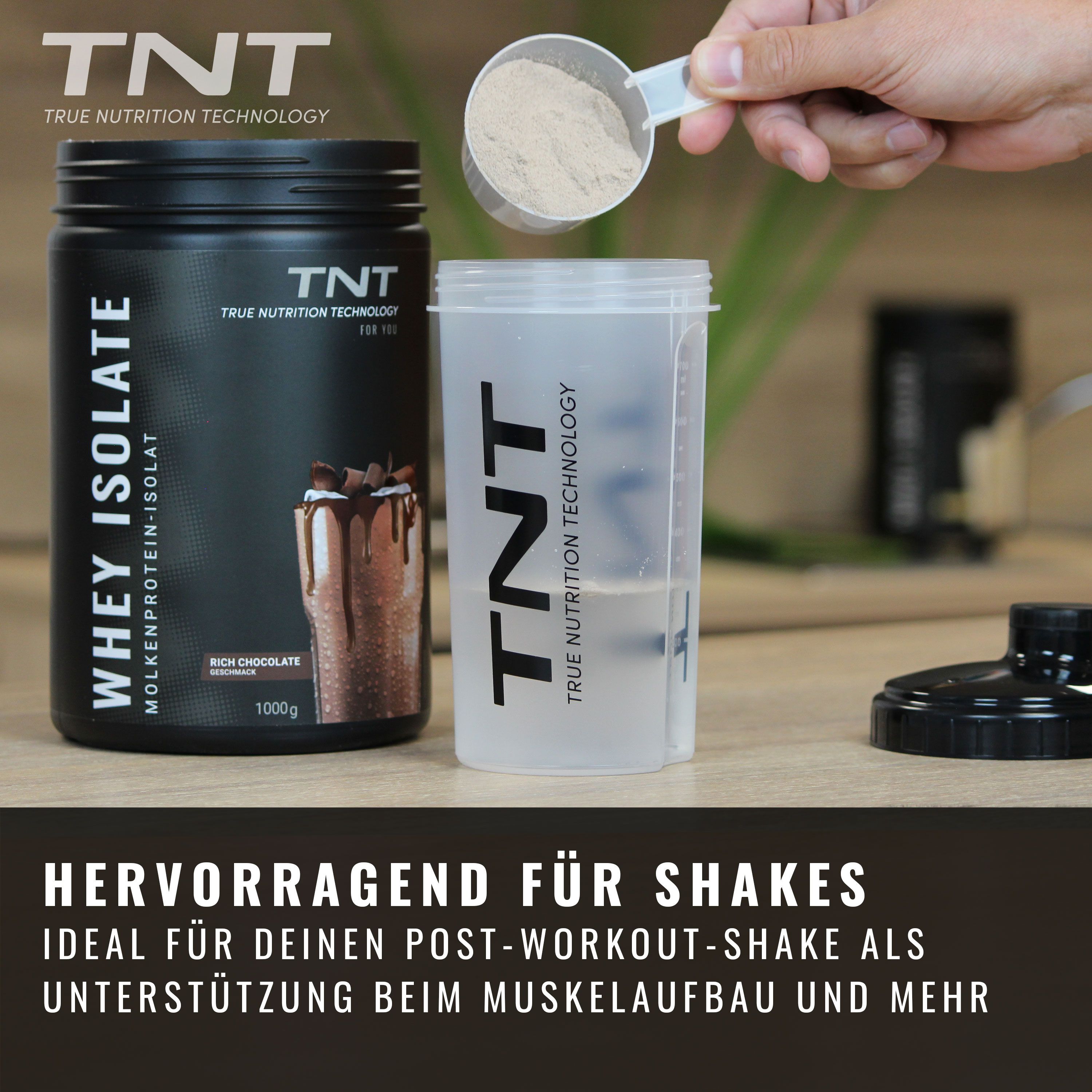 Schwarze Dose TNT True Whey Isolate neben Shaker. Pulver wird in Shaker gefüllt. Text: Hervorragend für Shakes.