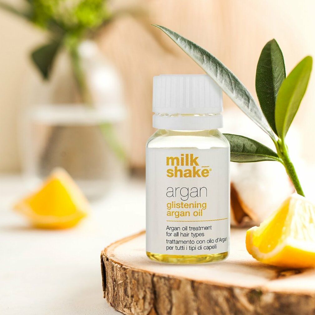 Glasflakon mit weißem Deckel auf Holzbrett. Aufschrift: Milk_shake, Argan Glistening Argan Oil. Dekoration.